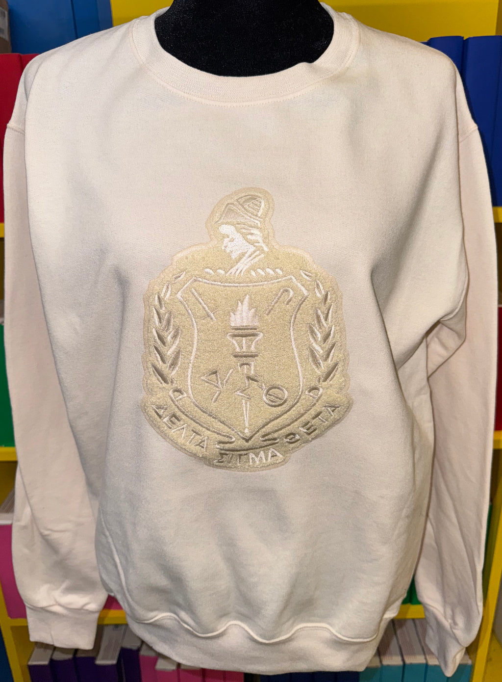 Cream on cream poly-cotton crewneck with a chenille patch of the Delta Sigma Theta Sorority Inc. Shield.